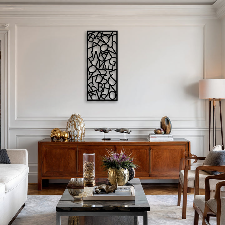 A bright white paneled wall serves as the elegant background for the unique abstract typography metal wall decor, above a warm wooden sideboard.