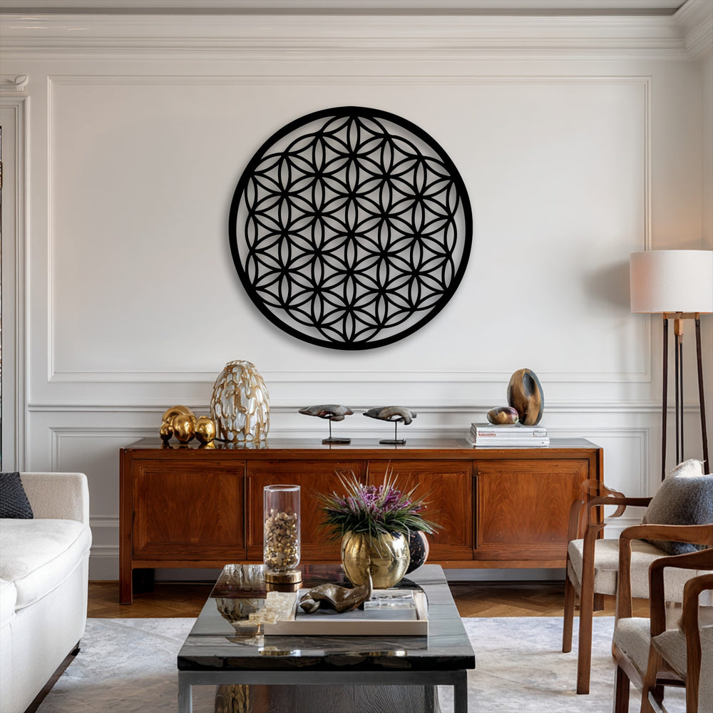 The brightly lit white wall highlights the intricate Flower of Life metal artwork, a captivating sacred geometry circle design.