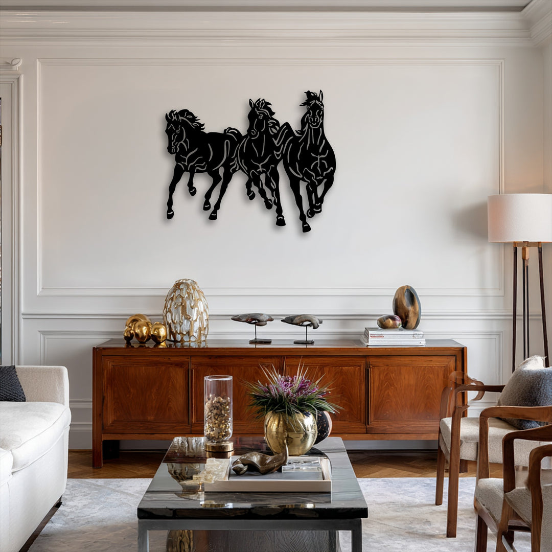 A striking display of three black silhouetted galloping horses, a dynamic trio of decorative metal art, charges across a bright white wall.