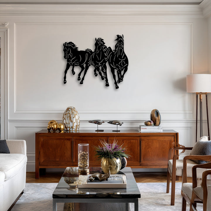 A striking display of three black silhouetted galloping horses, a dynamic trio of decorative metal art, charges across a bright white wall.