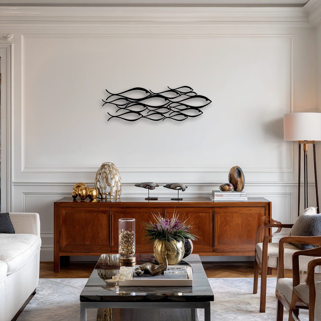 The minimalist metal wall decor, an abstract school of fish, creates a sense of depth and layers with its intricately arranged, flowing forms on the pale wall.