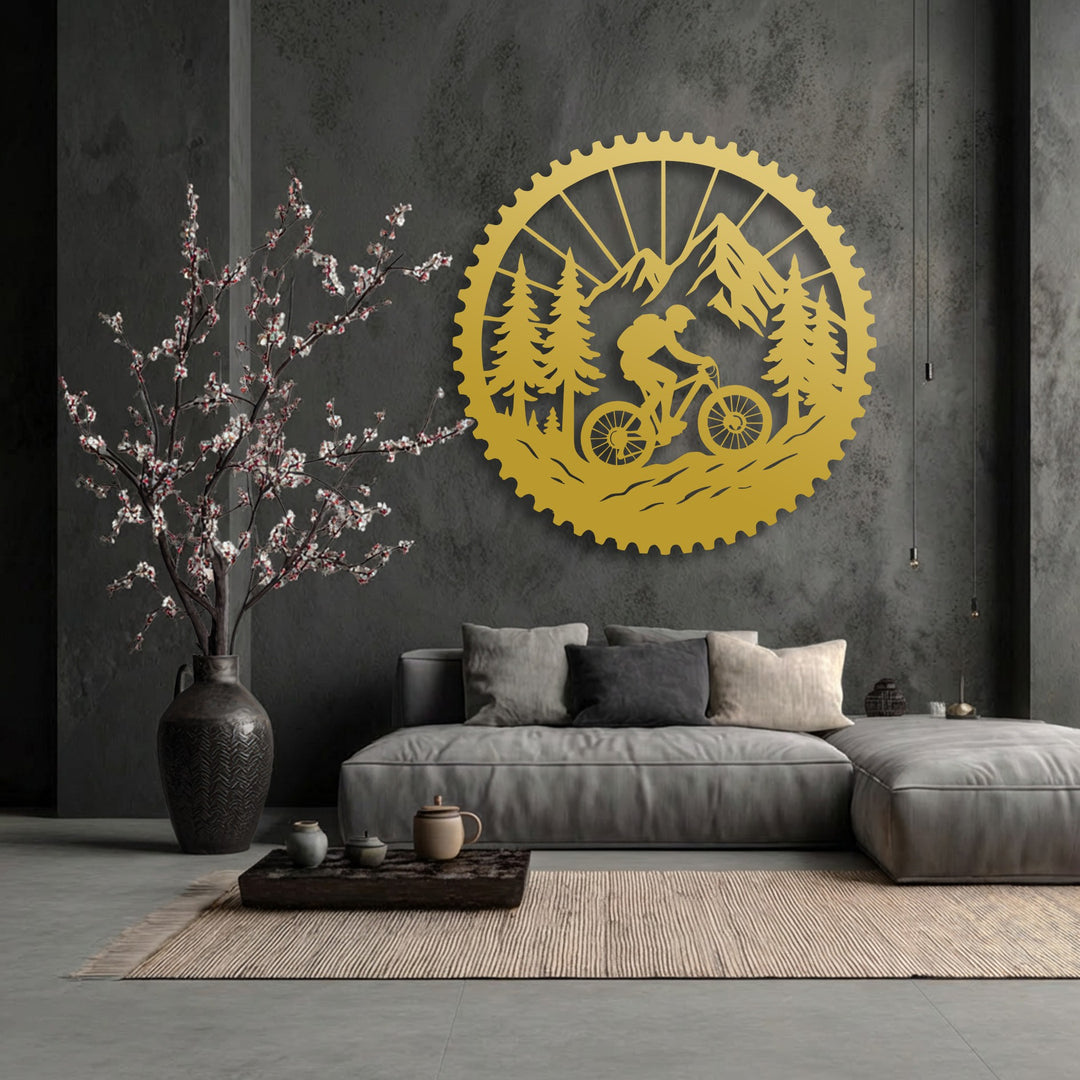 Golden metal decoration wall art vibrantly conveys movement, depicting a mountain biker on rugged trails within a striking forest and mountain scene.