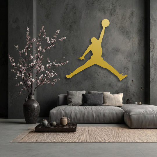 Focusing on the stillness of the golden basketball jump player metal art for wall, the dark textured room maintains a serene, modern ambiance.