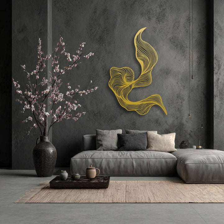 A vibrant, large golden abstract decorative metal art piece with fluid, swirling lines is the striking focal point in a modern dark grey living room.
