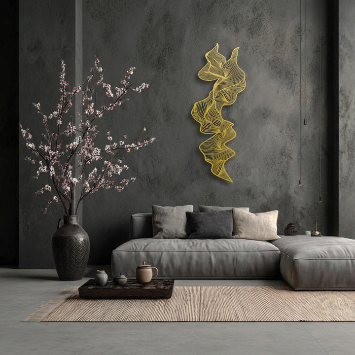 The loudest element is the striking golden abstract flowing lines of the vertical metal art for wall, dramatically contrasting with the dark gray textured wall.