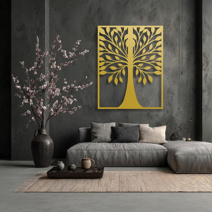 A vertically oriented rectangular symmetrical leaf tree silhouette golden metal art for wall elegantly adorns a dark grey wall.