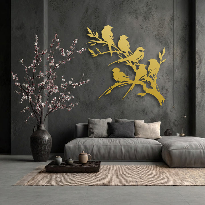 The visual rhythm of the elegant golden birds on branch metal artwork creates a harmonious flow against the dark wall, complementing the delicate blossoms.