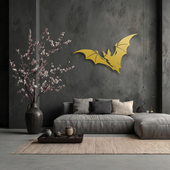 The negative space around the gold flying bat silhouette on the dark textured wall highlights this decorative metal art piece above a minimalist couch.