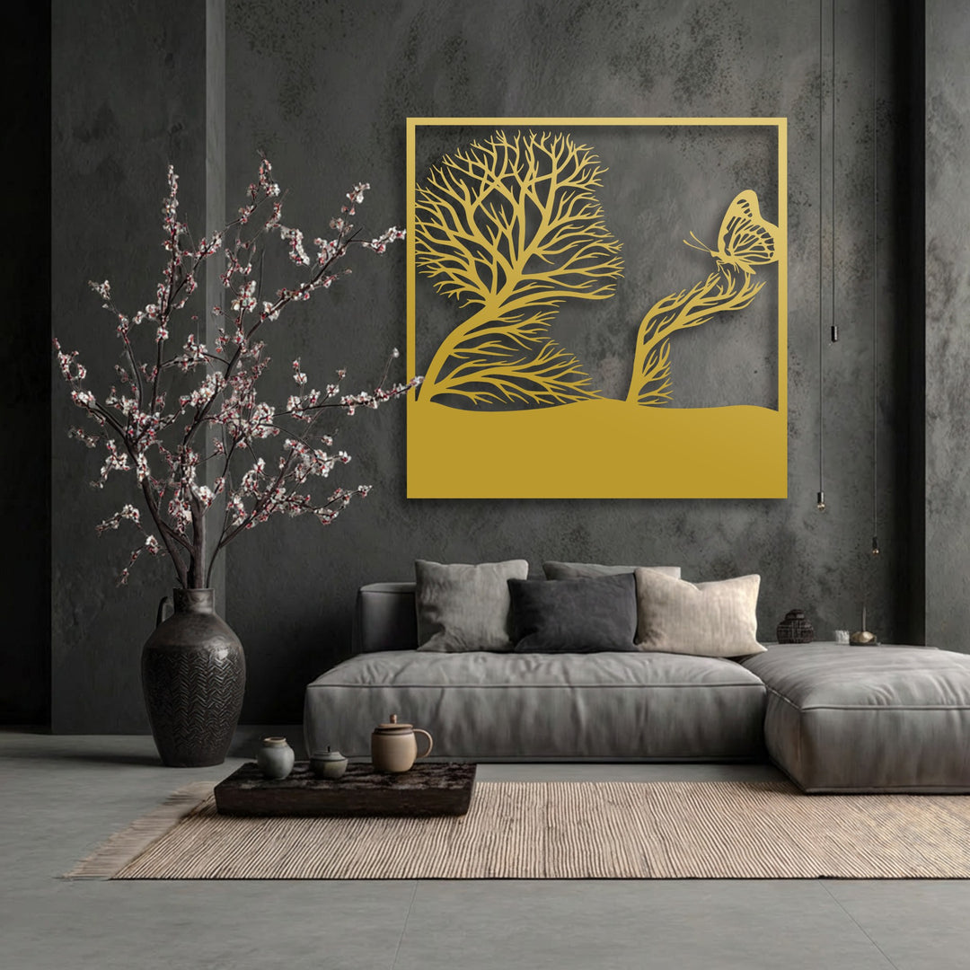 A golden unique metal wall art piece depicts a whimsical tree forming a profile and a butterfly on a branch, centrally displayed.