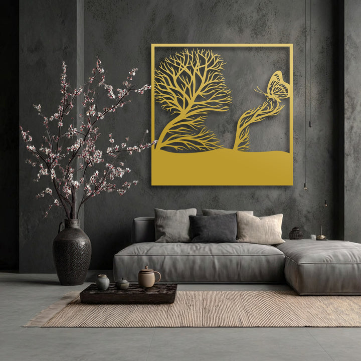 A golden unique metal wall art piece depicts a whimsical tree forming a profile and a butterfly on a branch, centrally displayed.
