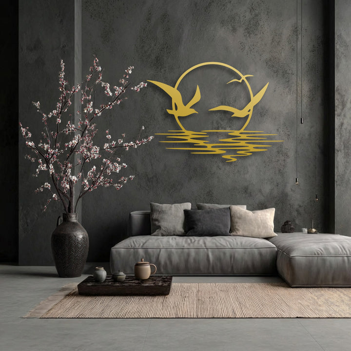 The focal point is a striking gold decorative metal art piece showcasing soaring seagulls against a circular sunset above stylized ocean waves.