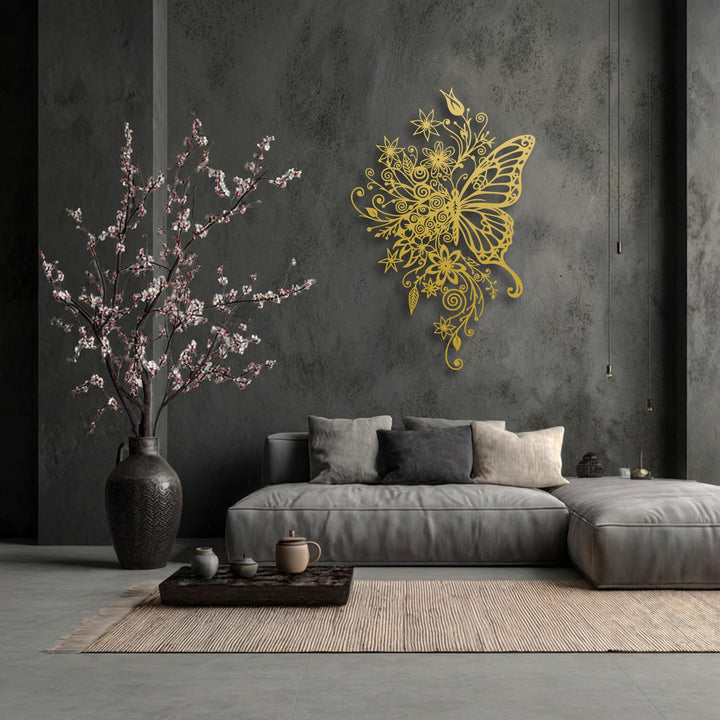 The lustrous golden finish of this ornate floral butterfly metal art for wall gleams against the dark, textured wall.
