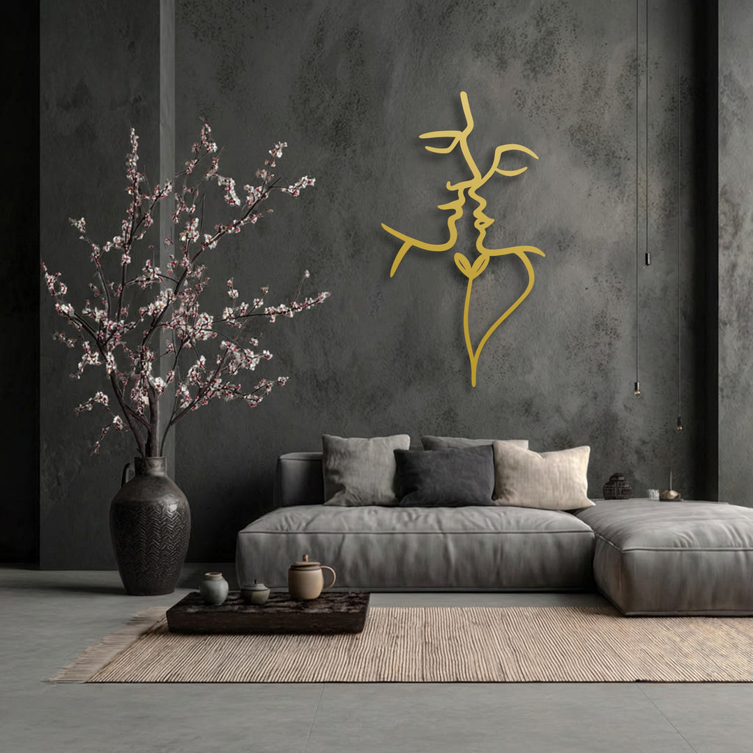 Negative space on a dark wall emphasizes the golden lines of decorative metal art, forming an abstract, intertwined minimalist face design.