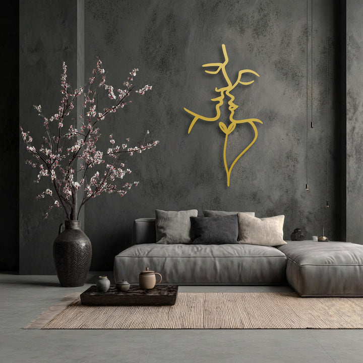 Negative space on a dark wall emphasizes the golden lines of decorative metal art, forming an abstract, intertwined minimalist face design.