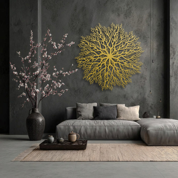 Soft light illuminating the golden unique metal wall art, a tree roots mandala, creates a dramatic play of shadows against the textured dark wall.