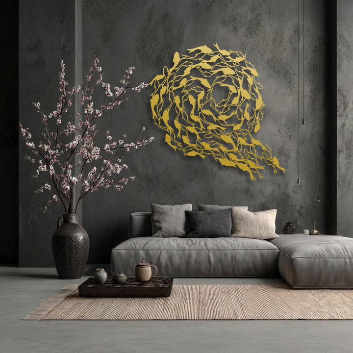 Delicate white and pink blossoms spill from a large vase, contrasting with the bold, golden unique metal wall art of koi fish swirling in a circle.
