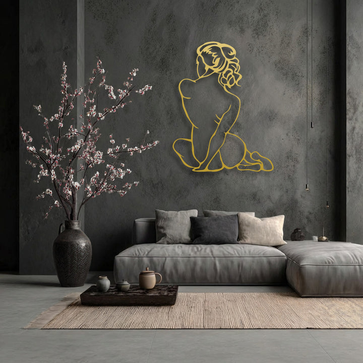 A minimalist golden outline of a female figure, a beautiful piece of decorative metal art, sits gracefully on a dark, textured wall.