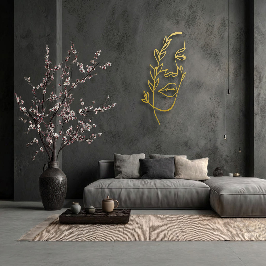 Golden minimalist female line art provides depth and layers, metal art for wall against a dark wall, with front blossoms.