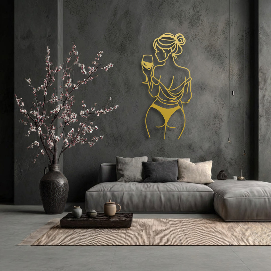 Featuring a striking golden finish, this elegant minimalist line art metal artwork portrays a woman with a wine glass.