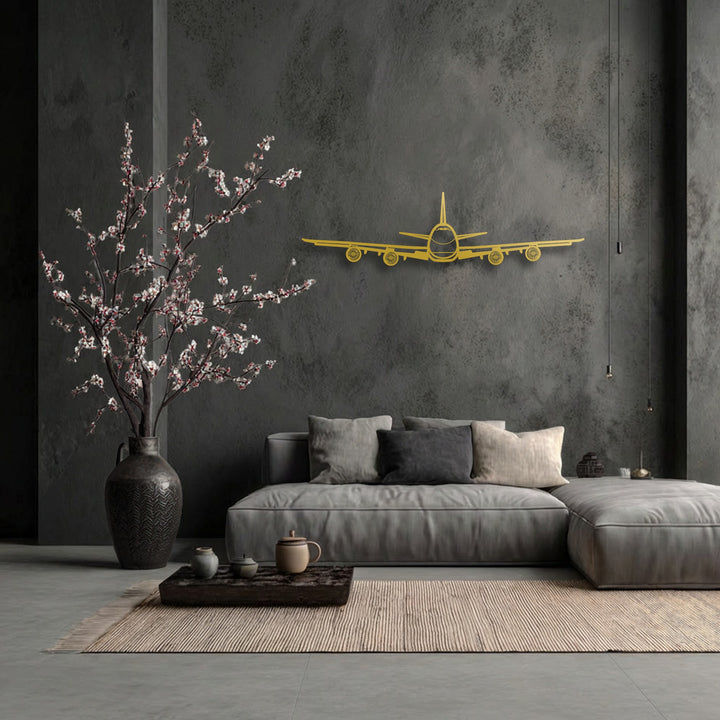 The smooth, golden surface texture of the Airplane Front View unique metal wall art stands out against the gritty dark gray wall.