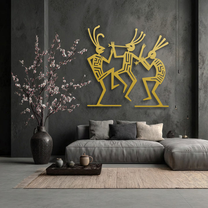 The muted color saturation of the room emphasizes the striking golden hue of the Tribal Dance Figures decorative metal art.