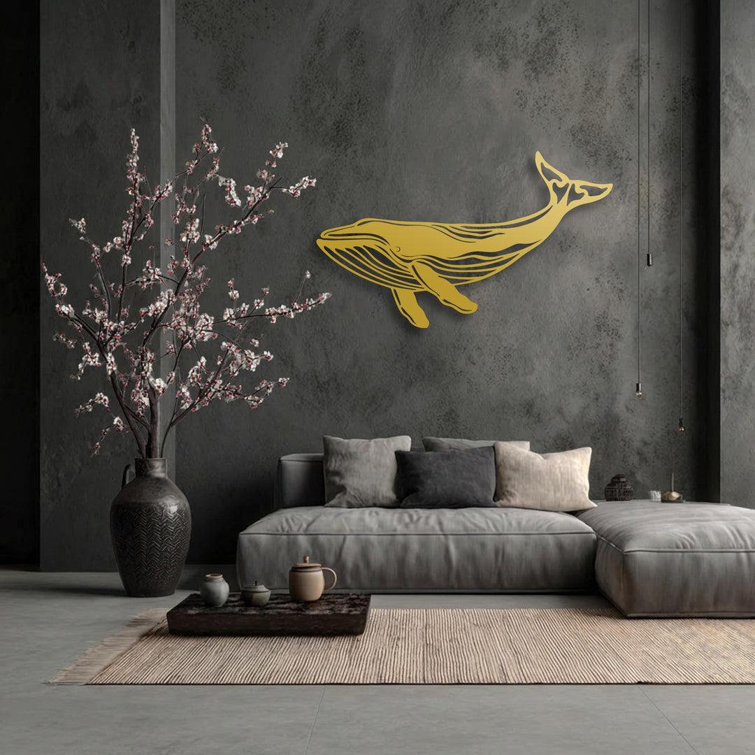 The exceptional material quality of this decorative metal art piece shines with a luxurious golden finish, highlighting the majestic whale silhouette.