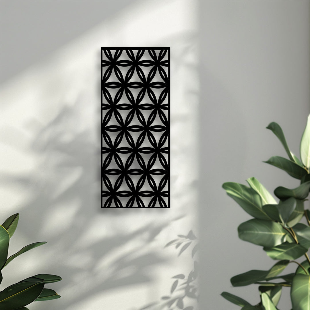 With realistic detail, the unique metal wall art's geometric floral pattern casts sharp shadows on the textured wall, with hints of green plant foliage.