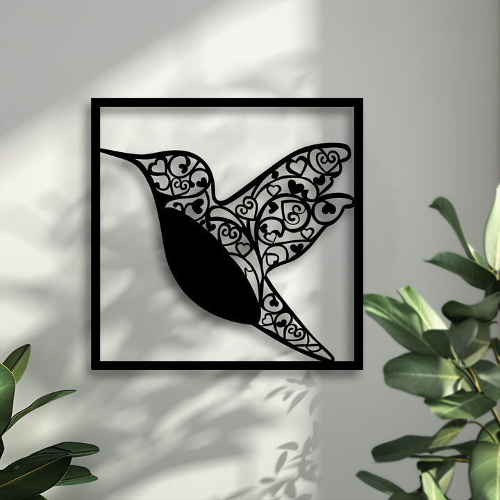 A striking matte black finish defines this unique metal wall art, beautifully depicting a graceful hummingbird heart.