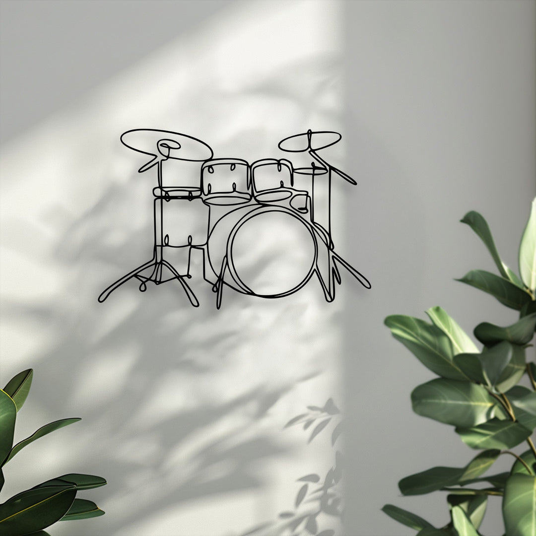Muted color saturation emphasizes the sleek minimalist drum set decorative metal art, displayed on a soft-hued wall with gentle shadows and green leaves.