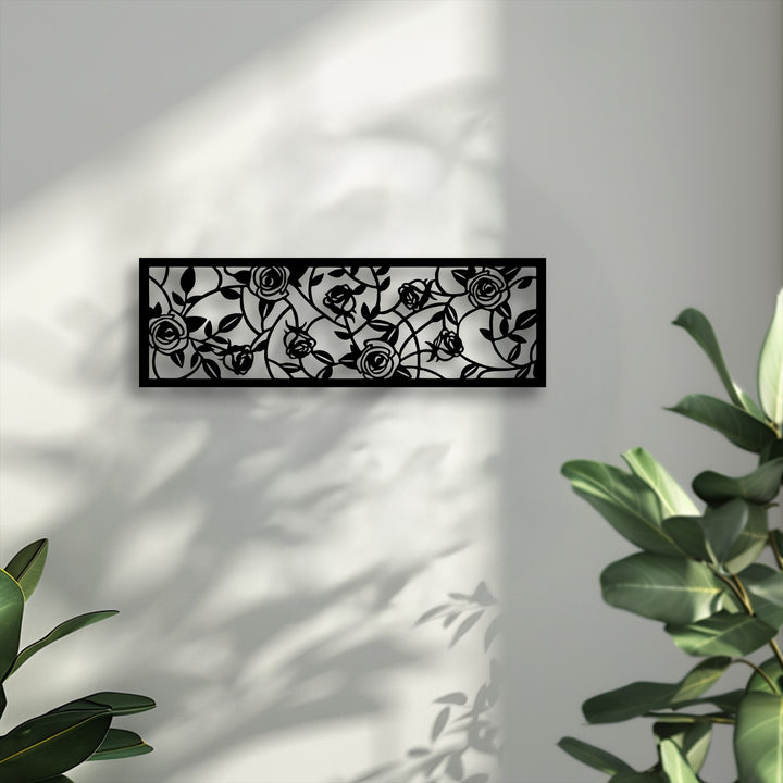 The finely textured white wall provides a soft backdrop for the smooth, intricate rose garden metal art for wall, highlighting its elegant floral vine panel.