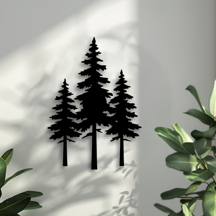 Geometric silhouettes of three pine trees form a unique metal wall art piece, casting distinct shadows on a textured white wall.