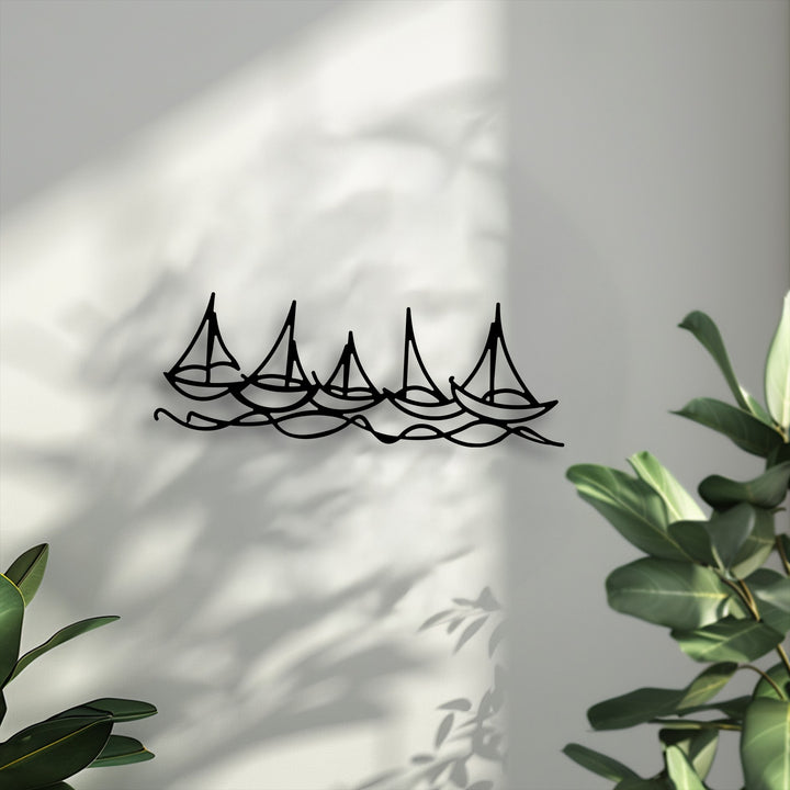The darkest area prominently features the minimal boat line metal artwork of five black sailboats navigating fluid waves.