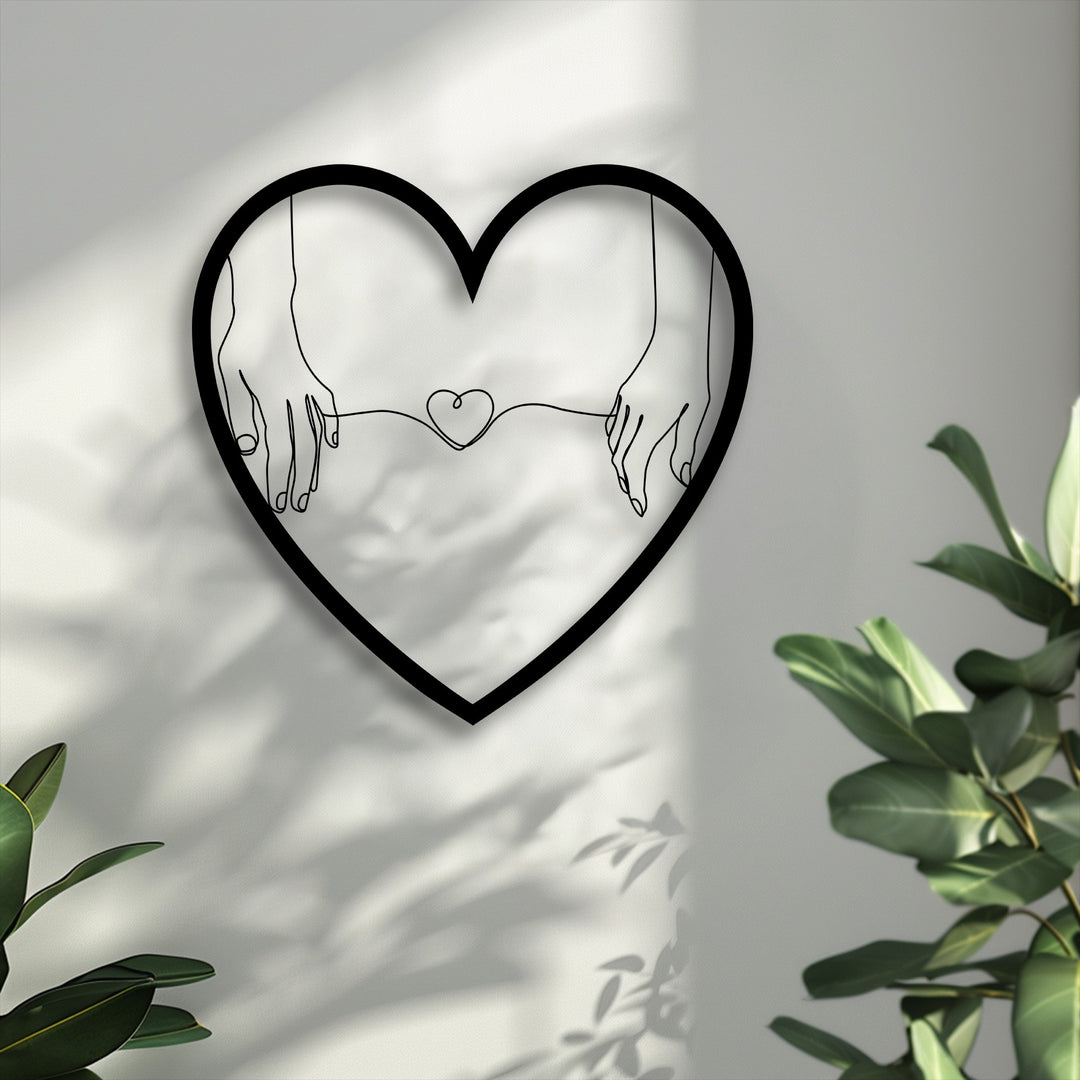 Organic forms of delicate hands holding a string heart within a minimalist love metal art for wall, casting artistic shadows.