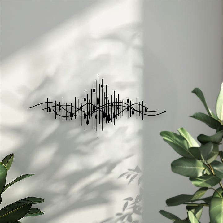 The stark color contrast of the black abstract soundwave decorative metal art pops against the bright white wall, enhanced by natural lighting.