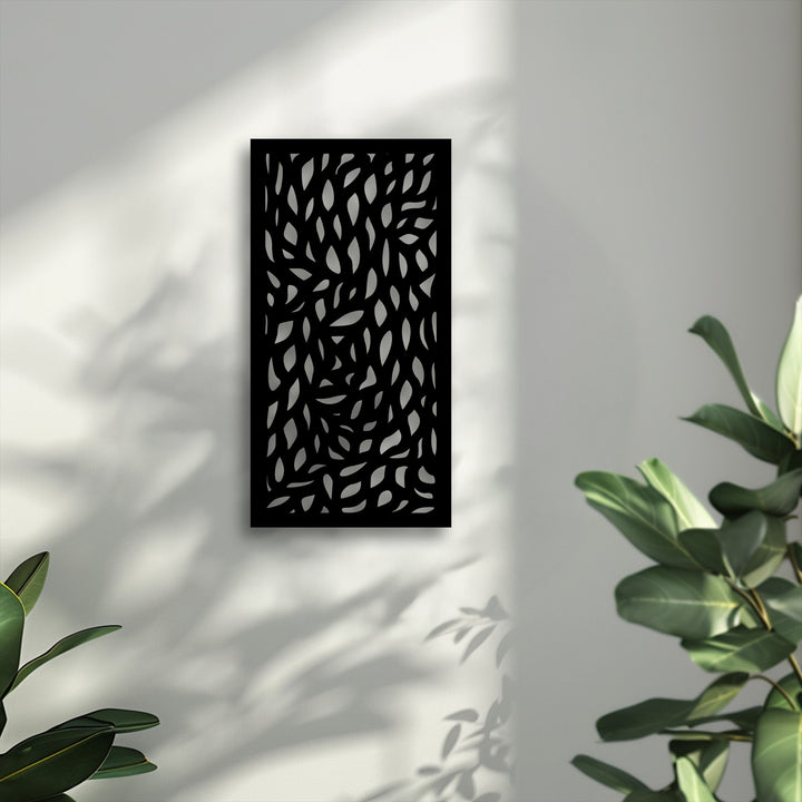 Soft, sunlit shadows from real leaves gently fall across the wall, complementing the bold abstract leaf pattern of the modern metal art for wall.