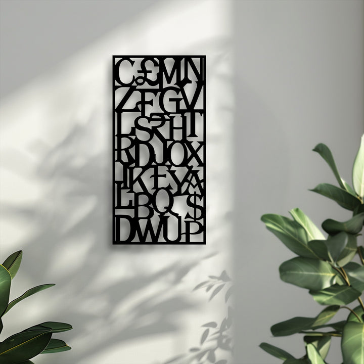 The subtle, fine texture of the wall contrasts with the smooth, matte surface of the black Abstract Alphabet Grid metal art for wall.