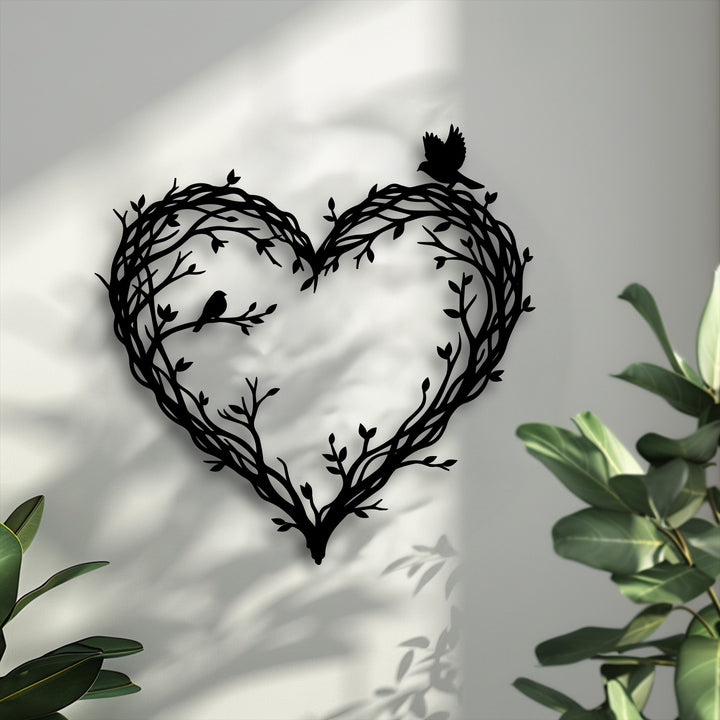 A decorative metal art piece, a heart of branches and birds, exhibits intriguing depth through its layered silhouette and dynamic wall shadows.