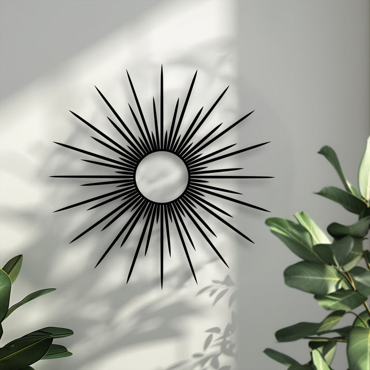 Visual rhythm emanates from the sunburst's radiating spikes, forming a unique metal wall art piece against a sun-dappled white wall.