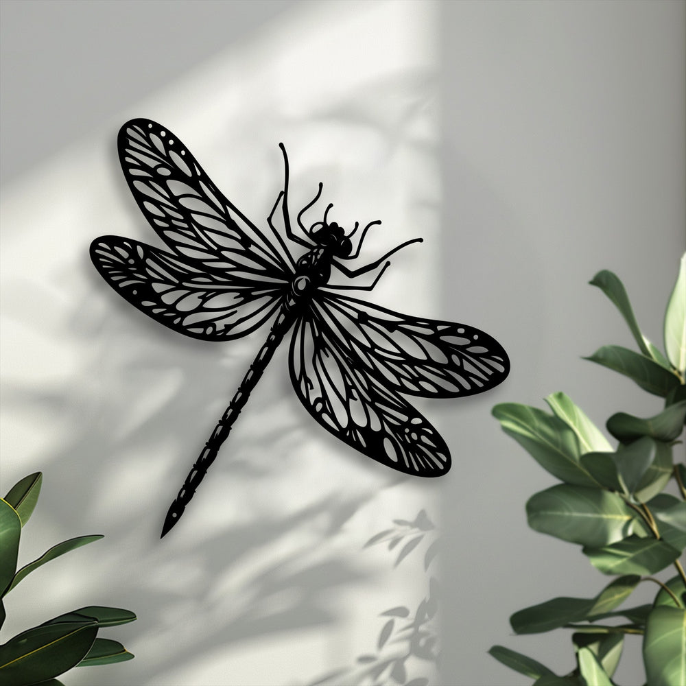 Highlighting depth and layers, the elegant metal dragonfly decoration wall art casts a shadow on a wall, accented by green foliage.