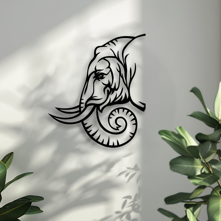 The background features soft, dappled plant shadows on a light grey, textured wall, enhancing the tribal inspired animal design metal wall decor.