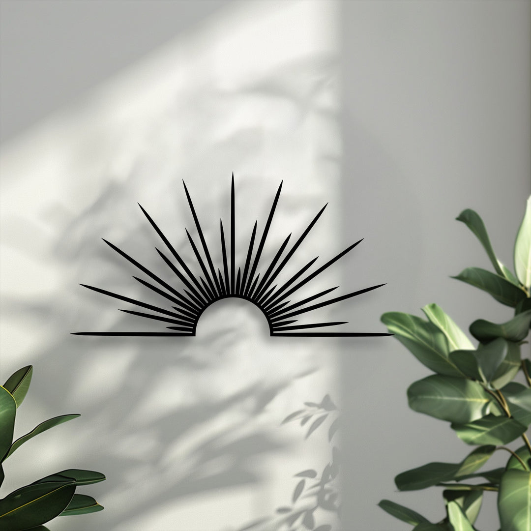 Light and shadow artistically define a minimal sunburst decorative metal art piece on a textured wall, with subtle plant silhouettes adding depth.