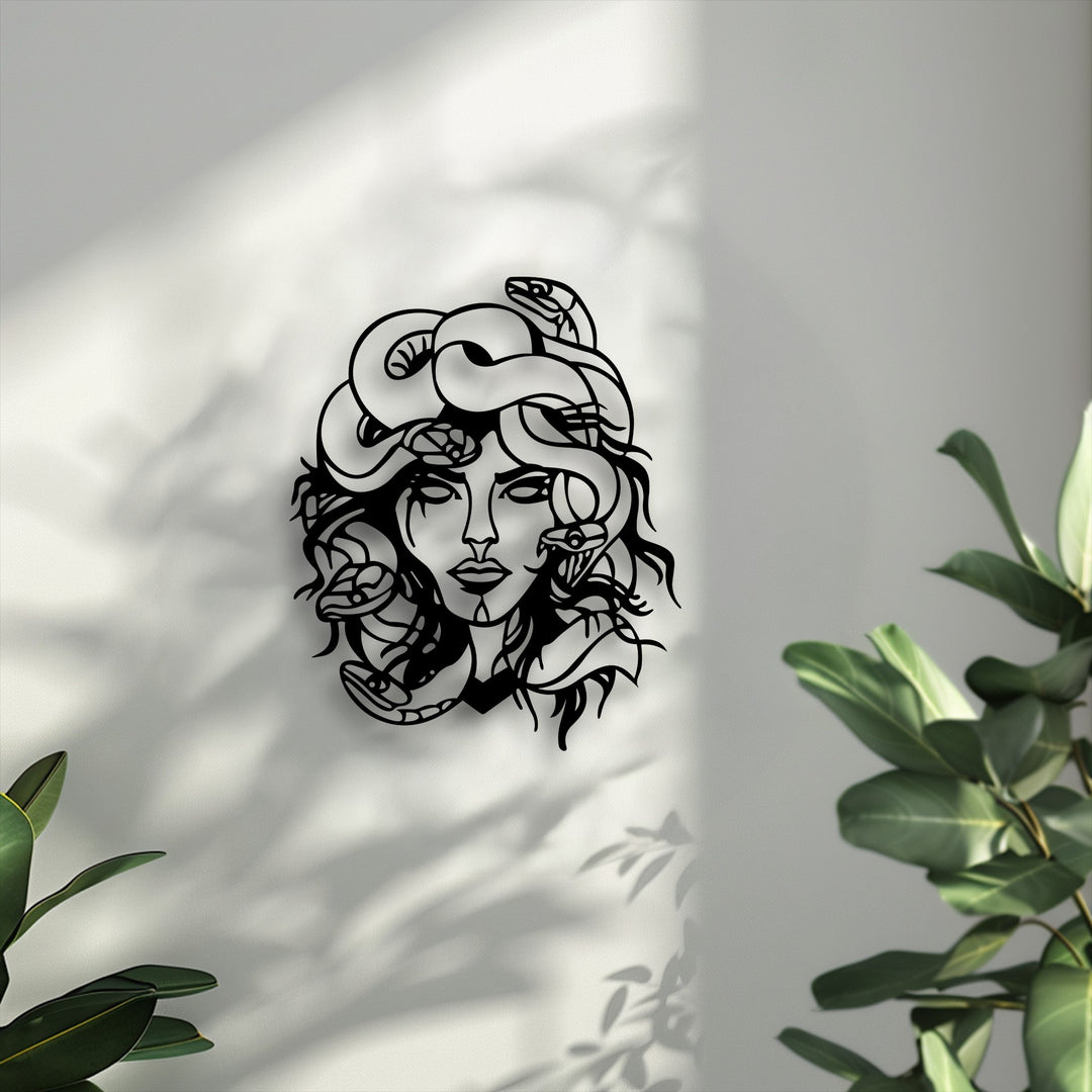 The striking black Medusa metal art for wall, intricately designed with snakes, casts captivating shadows on a bright textured surface.
