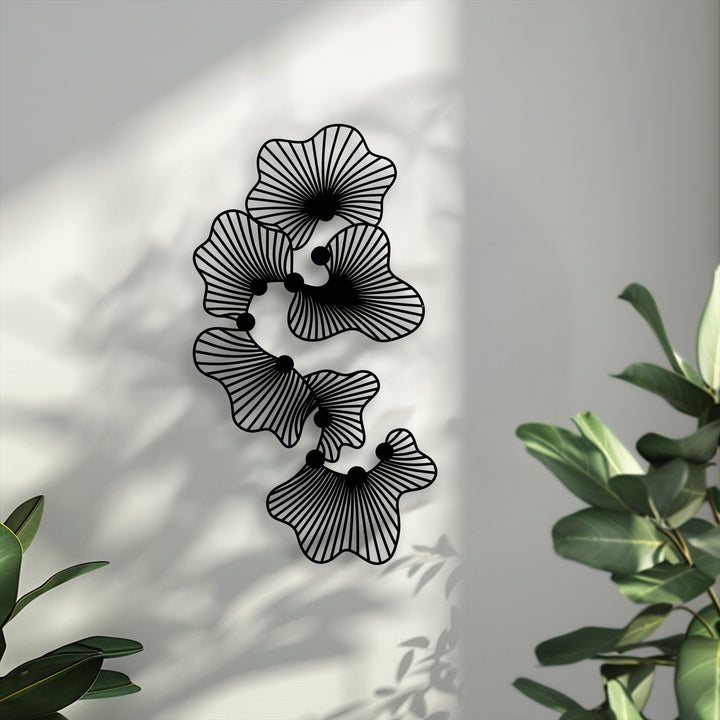 The stillness of abstract floral metal art for wall creates a tranquil scene, enhanced by soft shadows and lush green plants.