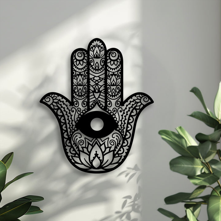 The Hamsa Hand metal wall art creates intricate shadows, adding layers of depth to the evil eye decoration wall art against a light background.