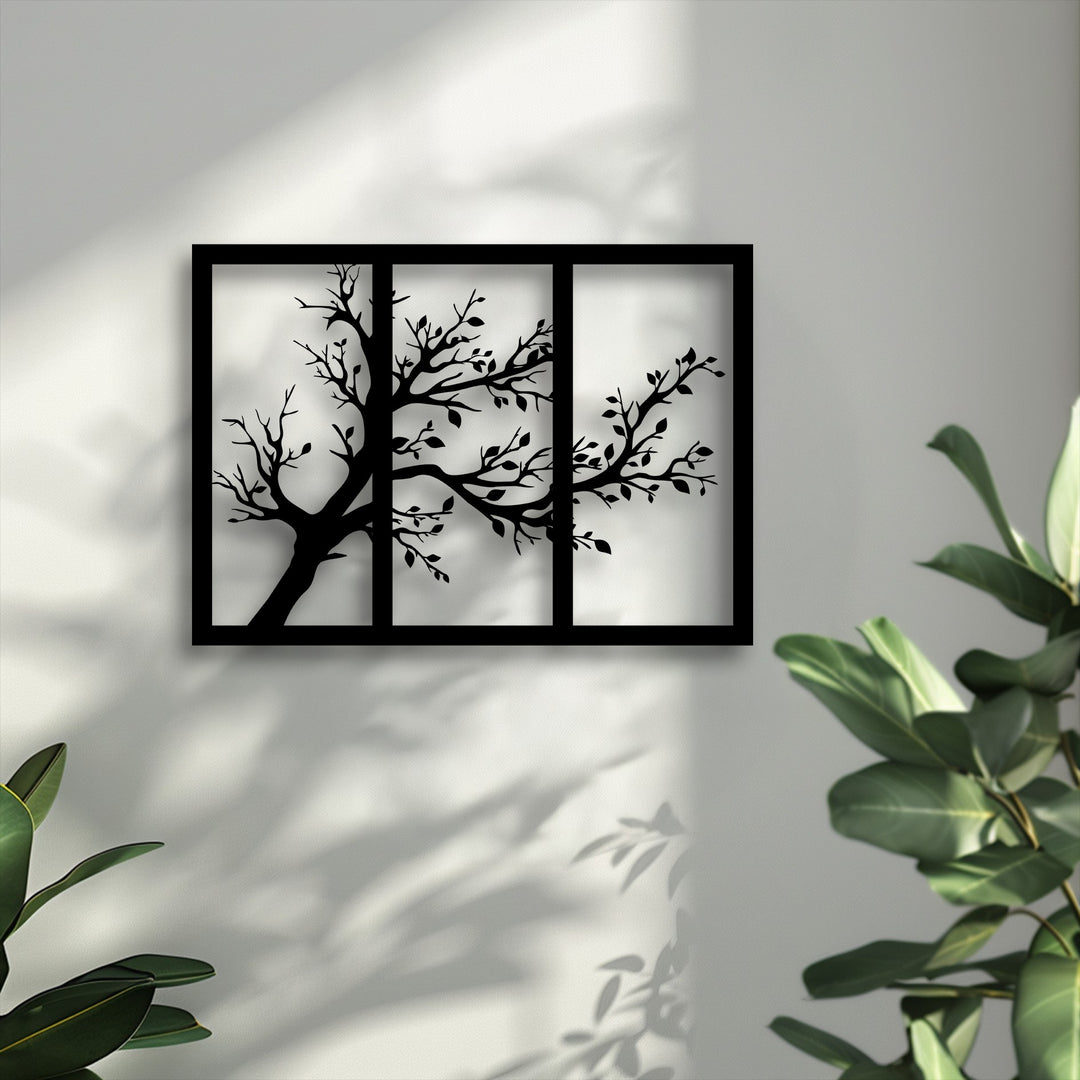 The bright negative space behind the black tree silhouette metal artwork emphasizes its delicate branches and triptych design.
