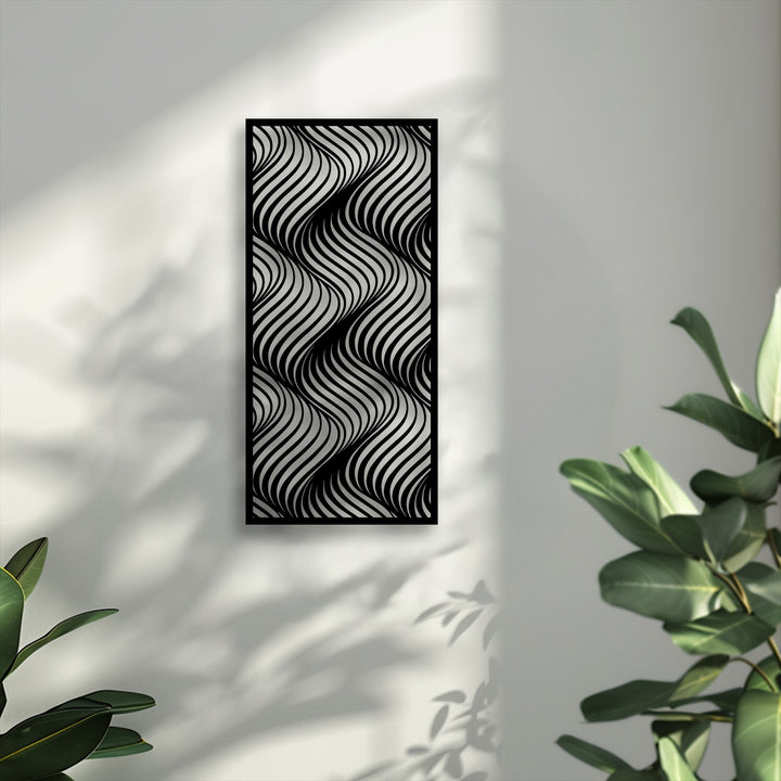 The bold black and white unique metal wall art, featuring a dynamic flowing wave pattern, casts intricate shadows across a textured white wall.