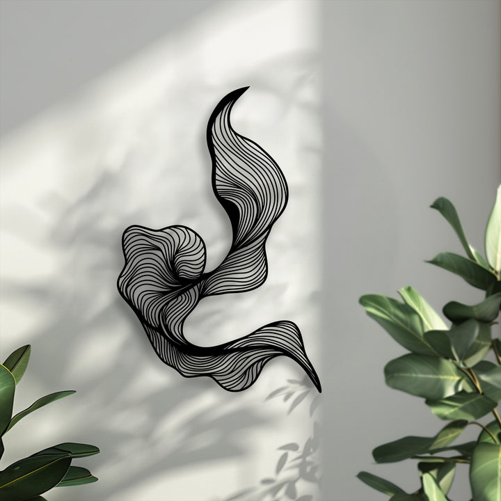 An elegant and serene ambiance is created by this fluid abstract lines metal wall decor piece, casting soft shadows on a bright wall.