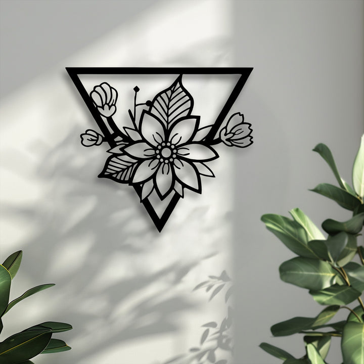 Striking black geometric floral blossom metal artwork with a modern triangle frame prominently displayed on a textured white wall.