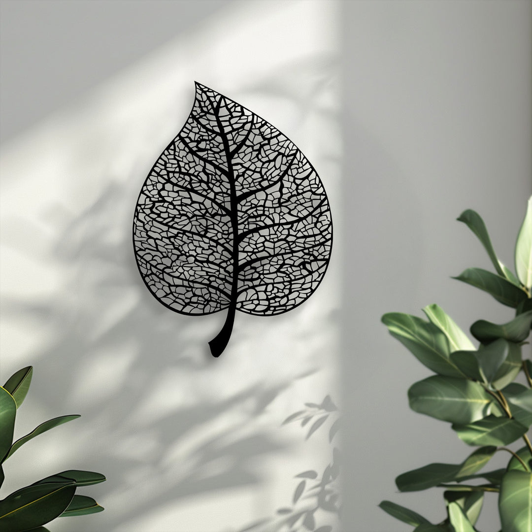 The gentle play of dappled sunlight and botanical shadows softly frames the elegant metal leaf decoration wall art.
