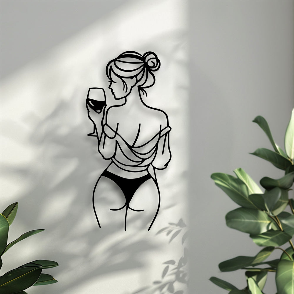 The cool color temperature highlights this minimal line art decorative metal art of a woman holding a wine glass against a softly shadowed wall.